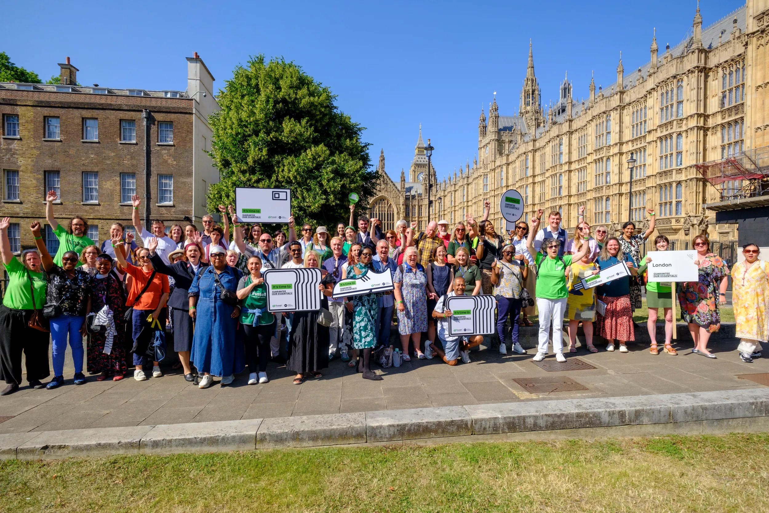 Campaigners gathered outside the UK Parliament holding Essentials Guarantee boards, calling for welfare reform to cover basic living costs.